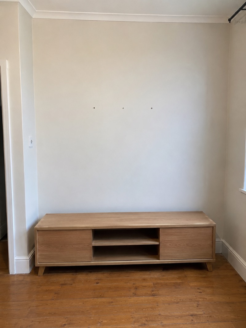 Before — bare wall and unit before TV mounting